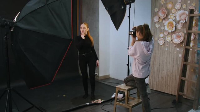 Young blonde woman model having a photo session in the studio. Shooting backstage