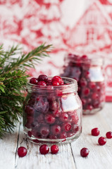 cranberries in a glass jar on a wooden table