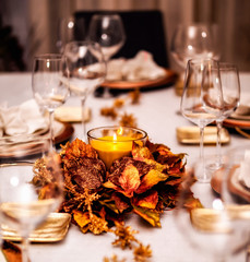 Festive table with beautiful decoration and lit candle.