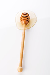 Honey and honey dipper on white background