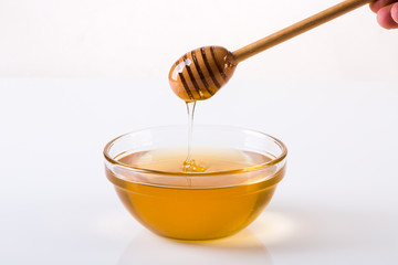 Honey bowl with dipper and flowing honey