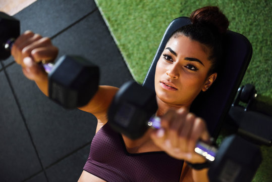 Woman training with dumbbells in a gym