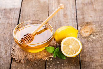 Honey with lemon and mint on wooden table