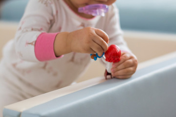 A baby's hand holding a toy 