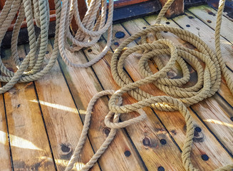 Thick old ropes on the wooden deck of the ship