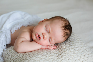 Portrait of cute sleeping newborn baby in light bedroom. Family, motherhood, love, health, innocence and care