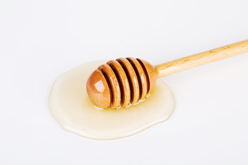 Honey and honey dipper on white background