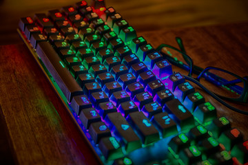 Fototapeta premium Podświetlana, zakurzona klawiatura z kolorowymi przyciskami LED RGB, wygląda jak nowoczesne urządzenie do hakowania gadżetów cyberpunk przyszłości z angielskimi i rosyjskimi literami