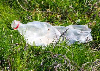 Old plastic bottle in the grass as trash
