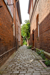 Historical cobblestone alley with red brick houses in the German medieval town Hitzacker.