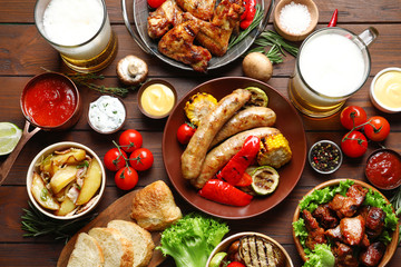 Delicious meal served for barbecue party on wooden table, flat lay