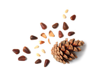 Composition with pine nuts and cone on white background, top view