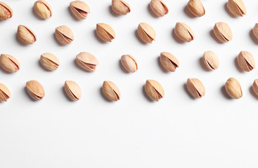 Organic pistachio nuts on white background, flat lay. Space for text