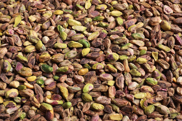 Shelled organic pistachio nuts as background, top view