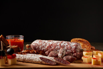dried sausage, spiced cheese on wooden board