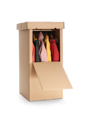 Cardboard wardrobe box with clothes on white background