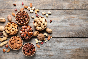 Flat lay composition with organic nuts and space for text on wooden background, top view. Snack mix