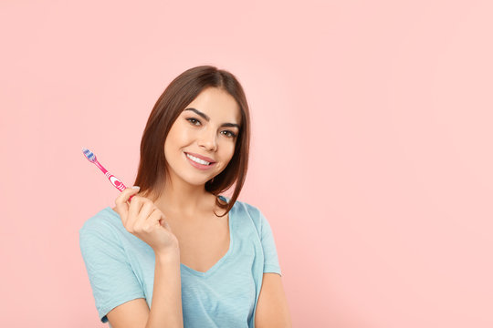 Beautiful woman with toothbrush on color background. Teeth care