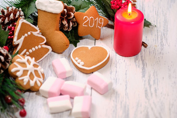 ginger biscuit and marshmallow on white background with Christmas tree ,  candles and christmas lights