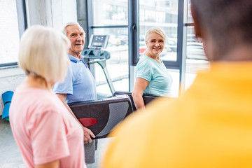 Obraz premium selective focus of senior sportspeople holding step platforms at gym