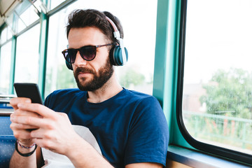 Young man riding in public transport listening to the music