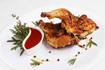 fried chicken on the grill with sauce, on a white plate