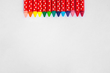 Row of Rainbow wax crayons isolated on white