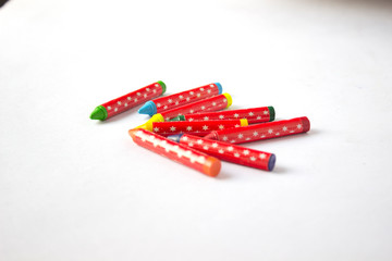 Obraz premium Jumbled group of multi-coloured wax crayons on white 