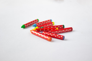 Jumbled group of multi-coloured wax crayons on white 
