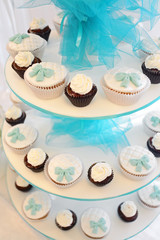 Candy bar. Cupcakes, decorated with a delicious sweet buffet, the concept of a festive table, a buffet table. Sweet muffins on three-tiered plates. Wedding table.