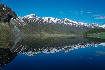 Fototapeta na wymiar Norway beautiful spring landscape. Mountains reflection in calm water of fjord