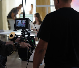 Behind the scenes of the camera when shooting a film, advertisement, video, team, actors. Shooting place, side view, focus on the hand with a raised finger