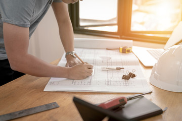 Fototapeta na wymiar architect or civil engineer during drawing home or building in office on working table with office stationary , laptop ,color pallette sampling.