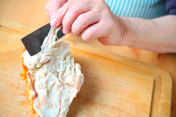 A man cuts the wishbone from a Thanksgiving turkey breast