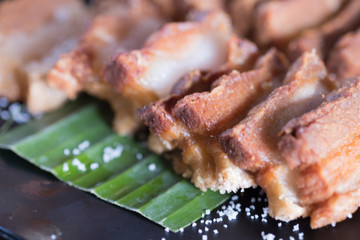 Slice of fried pork belly  with salted on banana leaf