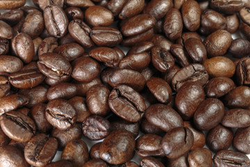 Well-roasted coffee beans background closeup.