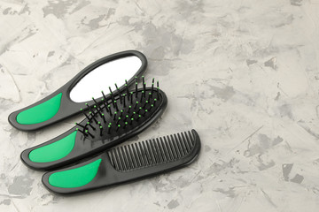 A set of different hair combs and hair accessories on a light concrete background. with space for text