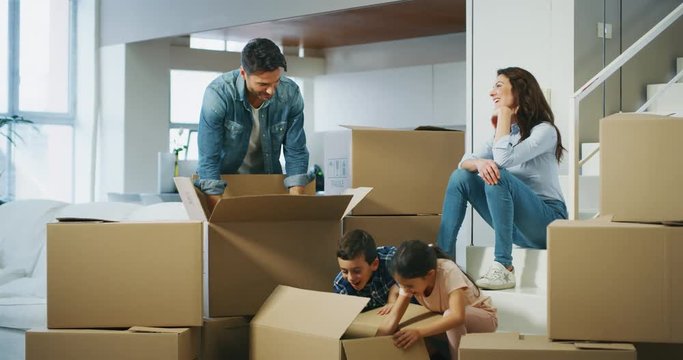 Slow motion of happy family bought new house  and unpacking boxes for moving into. 