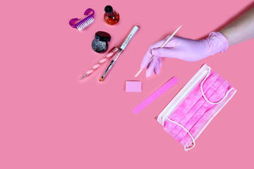 manicure and pedicure equipment. master nails in pink gloves holds manicure tool on the pink...