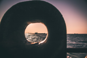cargo ship outgoing from port at sunrise