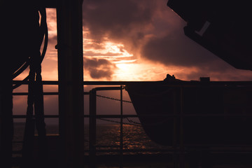cargo ship outgoing from port at sunrise