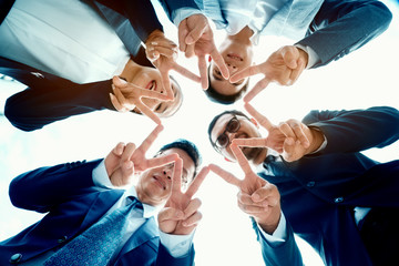 Fototapeta na wymiar Many young Asian businessmen are working on a big project. And overlapping hands to work together. Many people in the workplace are successful. Close-up of business partners. Happy co working concept