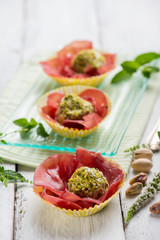 ricotta cheese meatballs with pisctachio nuts over bresaola