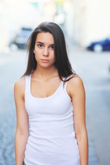 Hipster girl wearing blank white t-shirt and jeans posing against street road, minimalist urban clothing style, mockup for tshirt print store