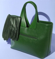 Fashionable leather bag, gloves on blue background, female accessories.