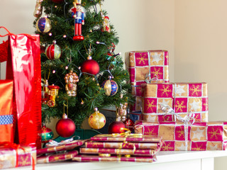 Artificial christmas tree with traditional decorations and many gifts - close up