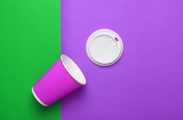 Empty paper coffee cup on a green violet background, top view, minimalism..