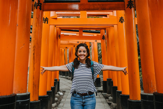 Young Occidental Woman Doing Sightseeing In The Fushimi Inari-taisha Shrine In Japan. Walking The Long Way To The Top Full Of Red Torii. Travel Photography. Lifestyle.