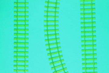 Obraz premium Toy railroad tracks on blue acid background. Top View.