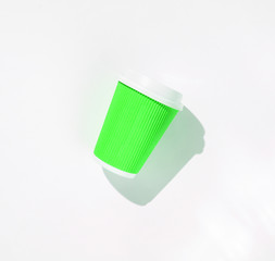 Paper cup of coffee on white background. Photo with shadows, hard light, top view.
